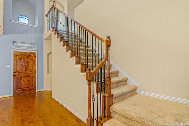 11806 Jasmine Way, San Antonio, TX 78253 - stairs featuring baseboards, wood finished floors, and a towering ceiling