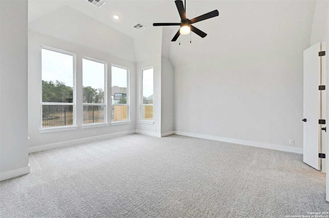 empty room with vaulted ceiling, light colored carpet, and ceiling fan