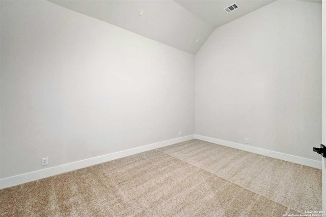 spare room featuring lofted ceiling and carpet flooring