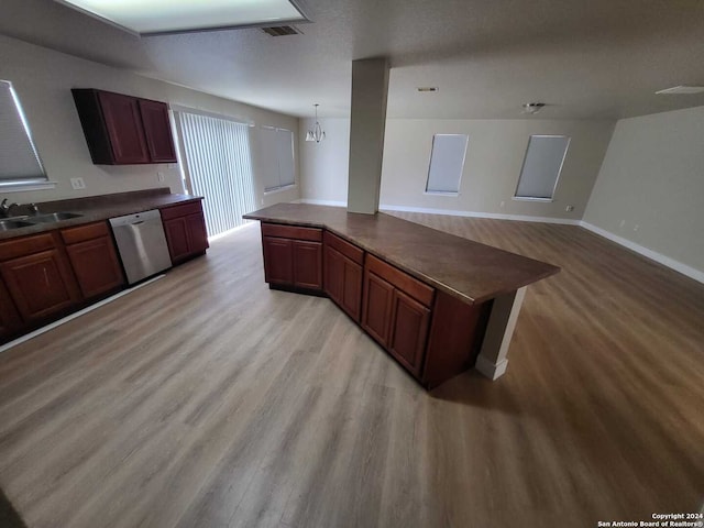 kitchen with pendant lighting, sink, stainless steel dishwasher, a notable chandelier, and light wood-type flooring