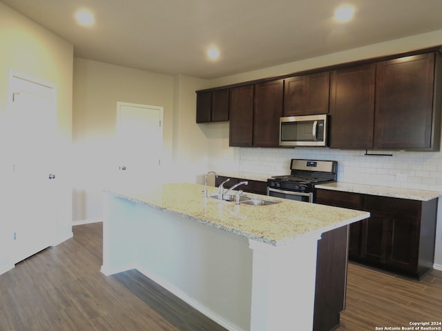 kitchen featuring stainless steel appliances, a center island with sink, hardwood / wood-style flooring, and sink