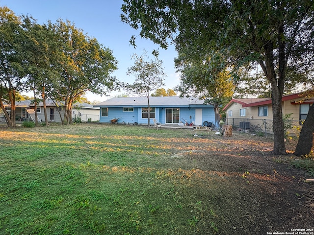 view of front of house featuring cooling unit and a front yard