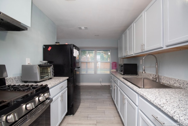 kitchen with white cabinets, appliances with stainless steel finishes, sink, and extractor fan