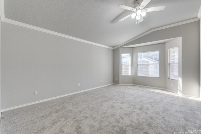 carpeted empty room with a textured ceiling, crown molding, lofted ceiling, and ceiling fan