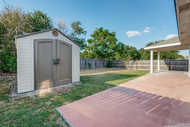 view of yard featuring a storage unit and a patio area