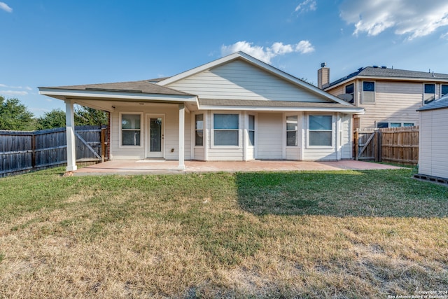 rear view of property featuring a yard and a patio