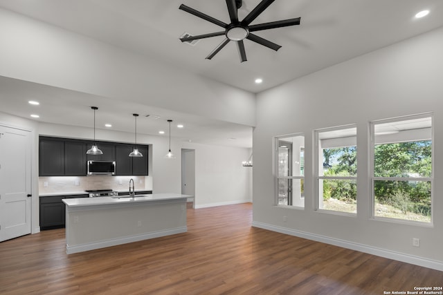 kitchen with hanging light fixtures, a kitchen island with sink, sink, and stainless steel appliances