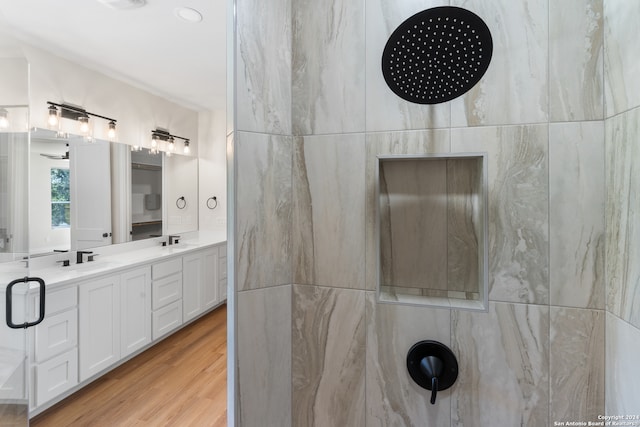 bathroom featuring tile walls, wood-type flooring, a shower, and vanity