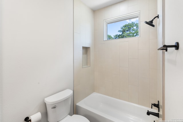 bathroom with tiled shower / bath combo and toilet