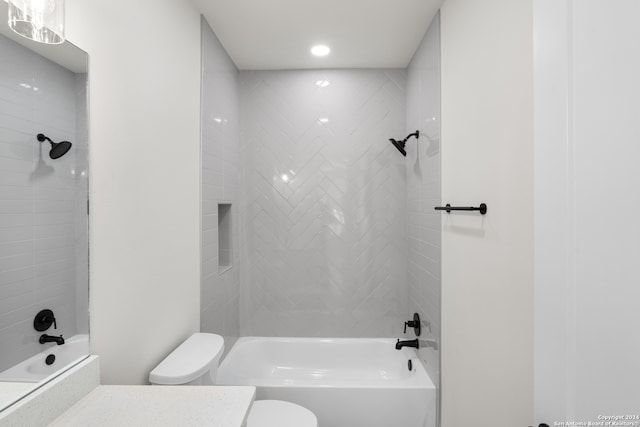 full bathroom featuring tiled shower / bath combo, vanity, and toilet