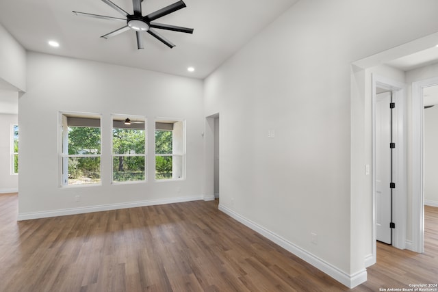 empty room with hardwood / wood-style flooring, plenty of natural light, and ceiling fan