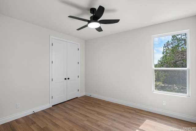 unfurnished bedroom featuring ceiling fan, a closet, and light hardwood / wood-style floors