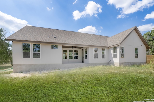 back of property featuring a lawn and ceiling fan