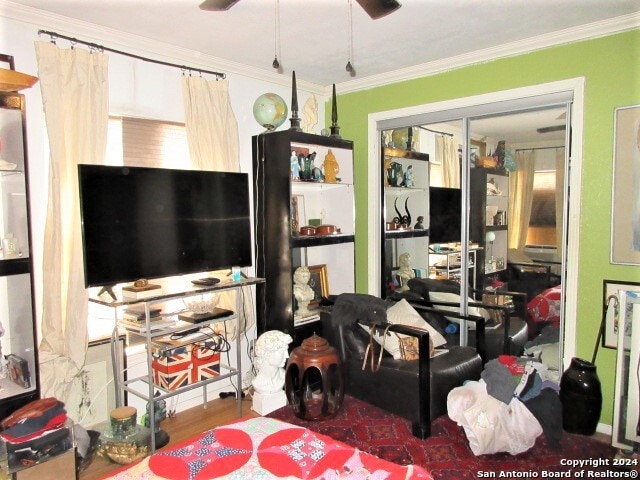 living room with ceiling fan and ornamental molding