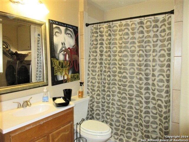 bathroom with a shower with shower curtain, vanity, washer / clothes dryer, and toilet