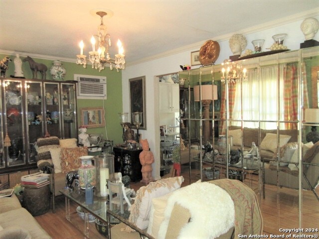 dining area with hardwood / wood-style floors, an AC wall unit, ornamental molding, and a notable chandelier