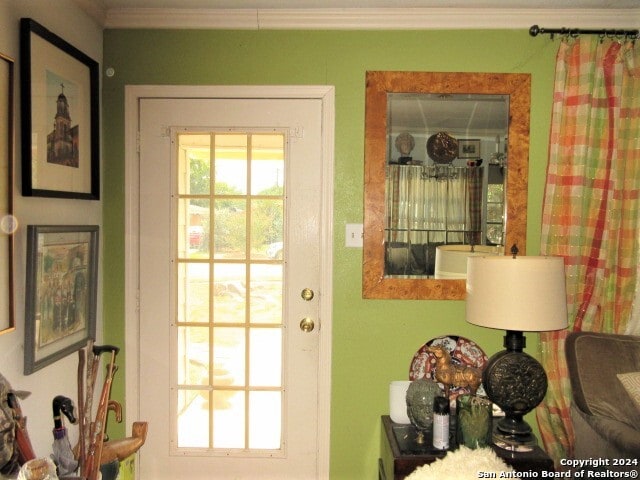 doorway to outside featuring crown molding