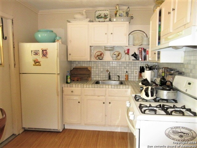 kitchen featuring white cabinets, white appliances, tasteful backsplash, and tile counters