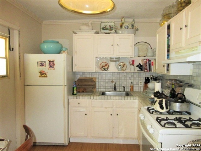 kitchen featuring white cabinetry, sink, tasteful backsplash, tile countertops, and white appliances