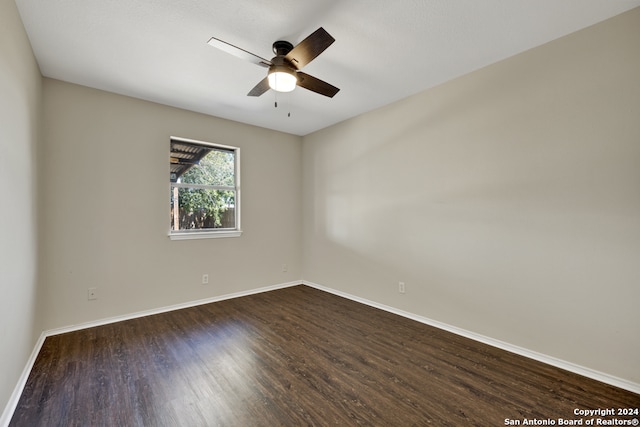 unfurnished room with ceiling fan and dark wood-type flooring