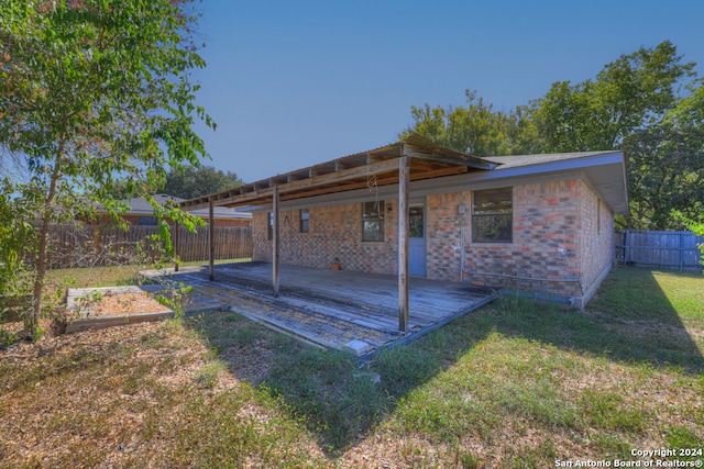 back of property with a lawn and a wooden deck