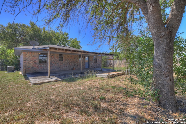 back of property featuring a lawn, central air condition unit, and a patio