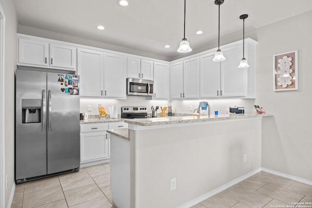 kitchen with light stone counters, white cabinets, appliances with stainless steel finishes, and kitchen peninsula