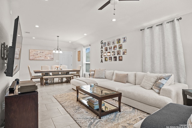 tiled living room featuring ceiling fan with notable chandelier