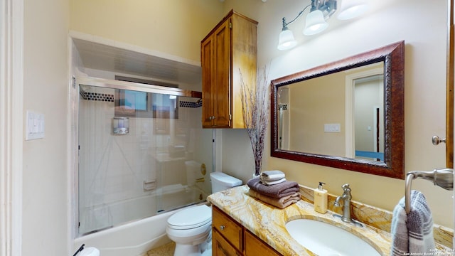 full bathroom featuring enclosed tub / shower combo, vanity, and toilet