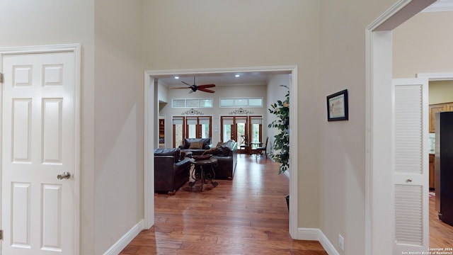 hallway with crown molding, dark wood-type flooring, and french doors