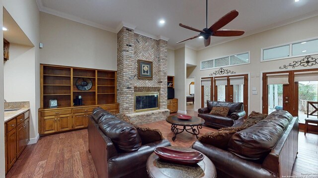 living room featuring crown molding, a high ceiling, and hardwood / wood-style flooring