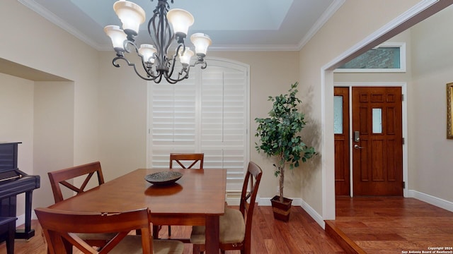 dining room featuring crown molding, a chandelier, and hardwood / wood-style flooring