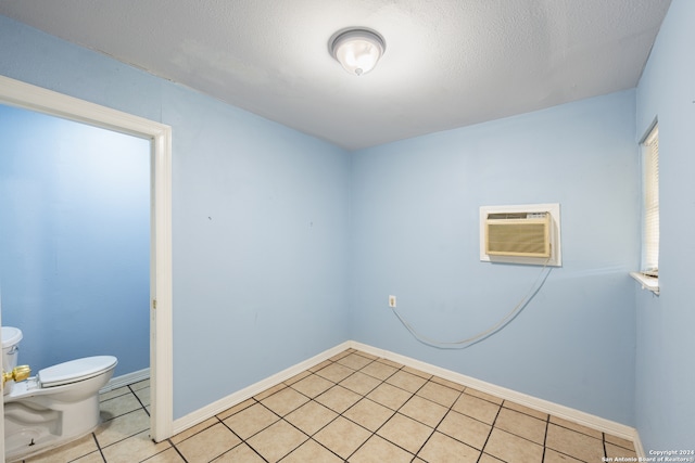 tiled spare room with a textured ceiling and a wall mounted AC