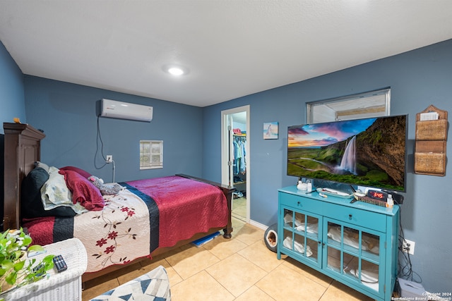 tiled bedroom featuring a wall mounted AC, a closet, and a walk in closet