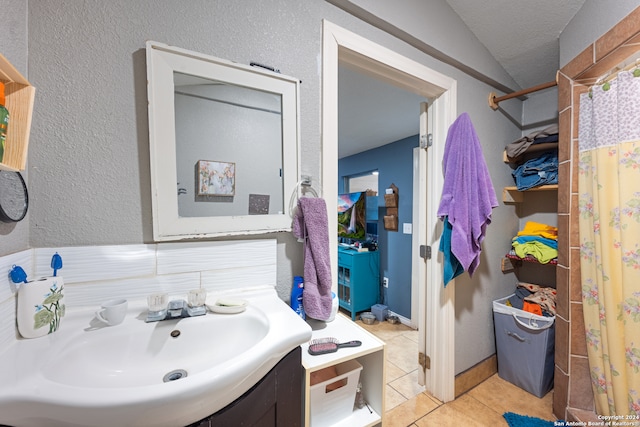 bathroom with tile patterned flooring, vanity, vaulted ceiling, and a shower with curtain