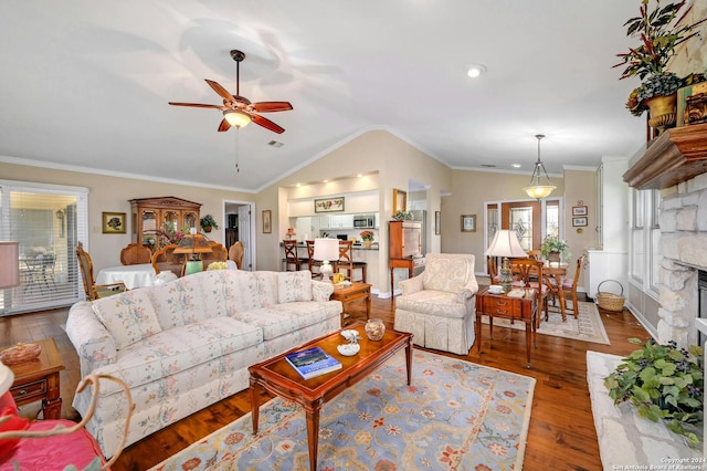 living room featuring wood-type flooring, a stone fireplace, ornamental molding, and ceiling fan