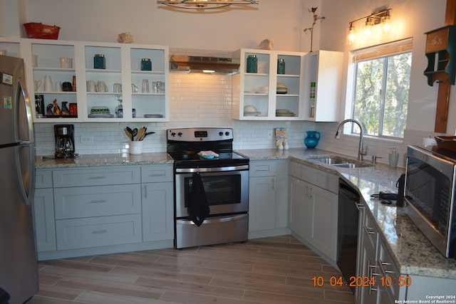 kitchen with ventilation hood, sink, white cabinetry, decorative backsplash, and stainless steel appliances