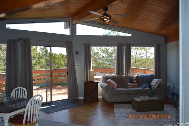 living room with lofted ceiling with beams, plenty of natural light, and dark wood-type flooring