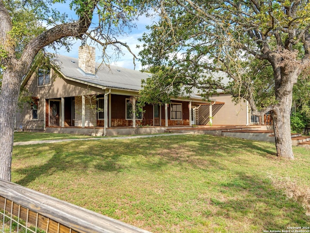 view of front facade with a front yard and covered porch