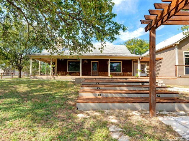 view of front of home with a pergola and a front lawn