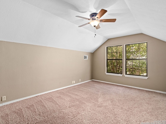 bonus room featuring vaulted ceiling, a textured ceiling, carpet floors, and ceiling fan