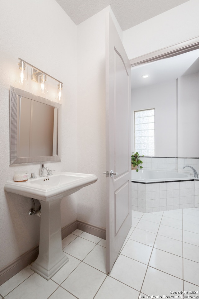 bathroom with tile patterned floors and tiled tub