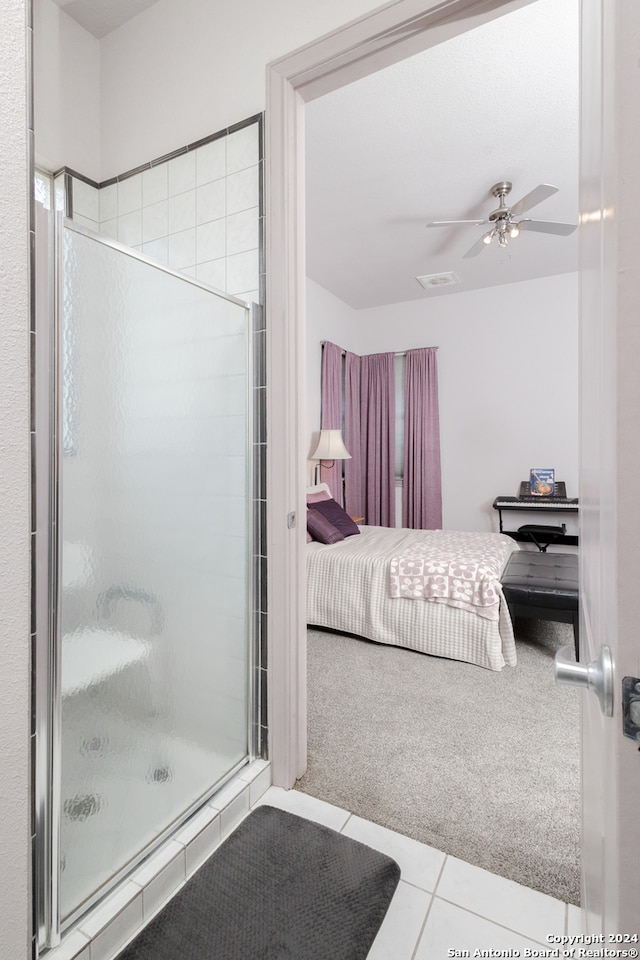 bathroom with a shower with door, ceiling fan, and tile patterned floors