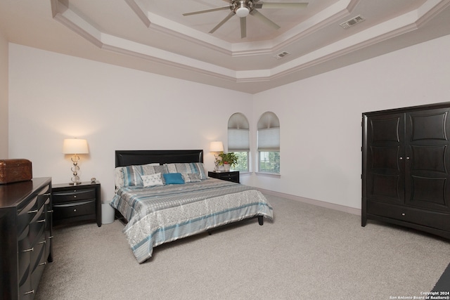 bedroom with light carpet, a tray ceiling, and ceiling fan