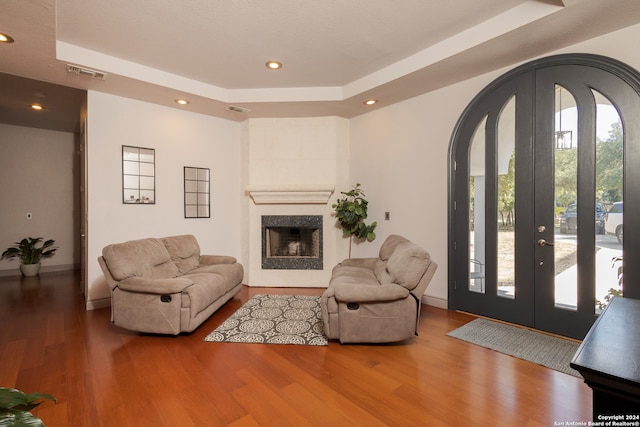 living room featuring wood-type flooring and a tray ceiling