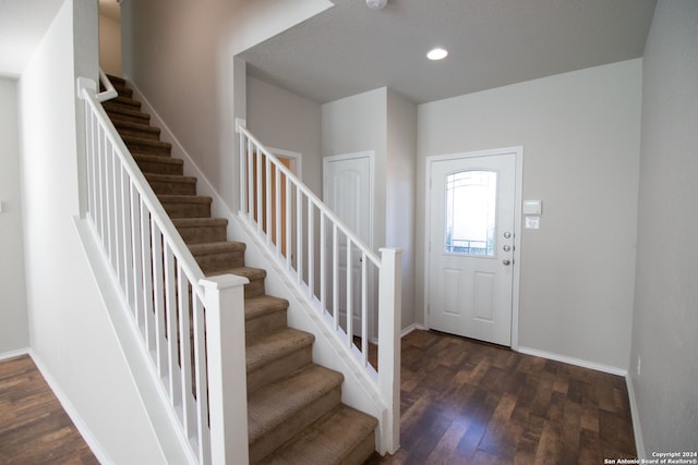 foyer featuring a textured ceiling and dark wood-type flooring