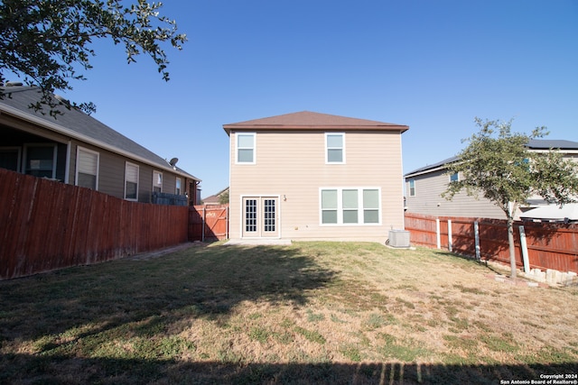 back of property featuring a yard and central air condition unit