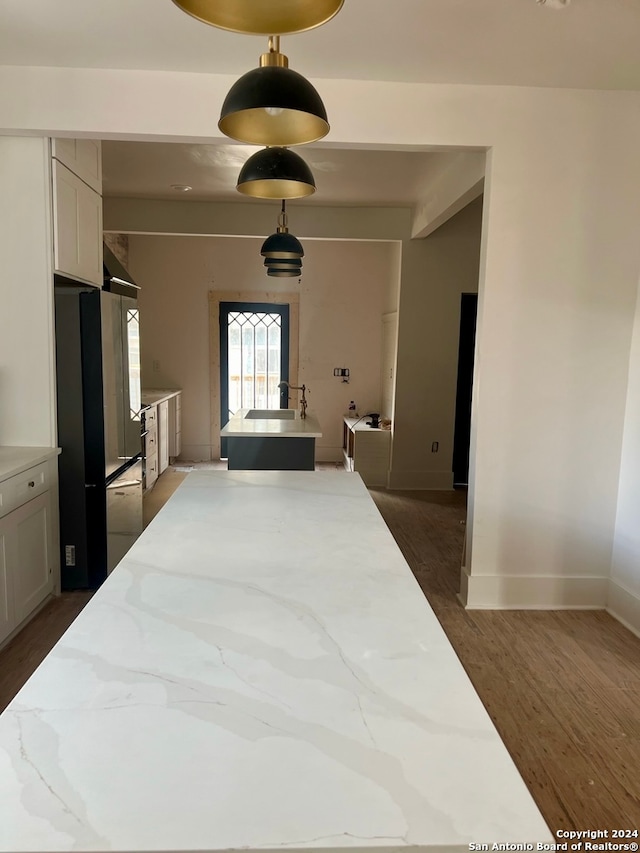 bedroom with stainless steel refrigerator and dark wood-type flooring