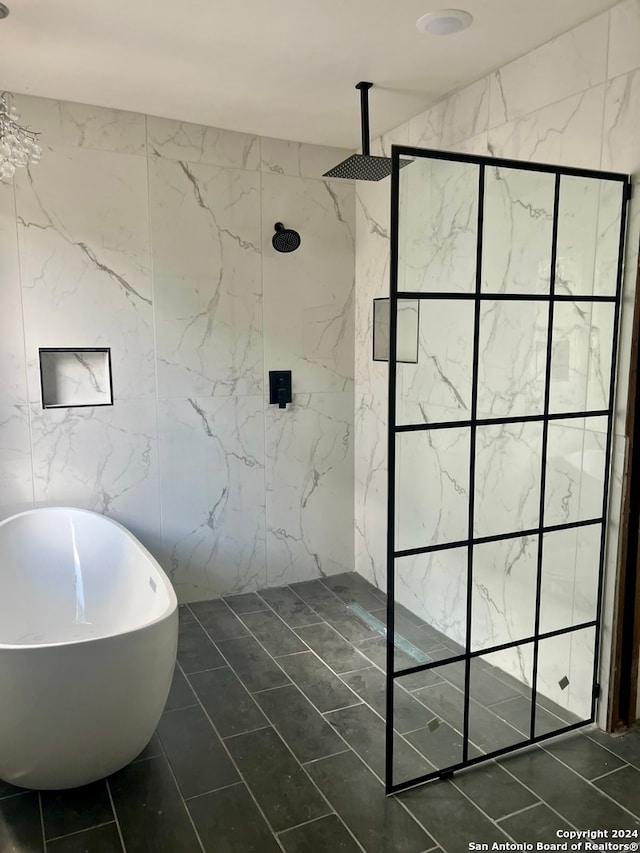 bathroom with tile walls, tile patterned flooring, and separate shower and tub