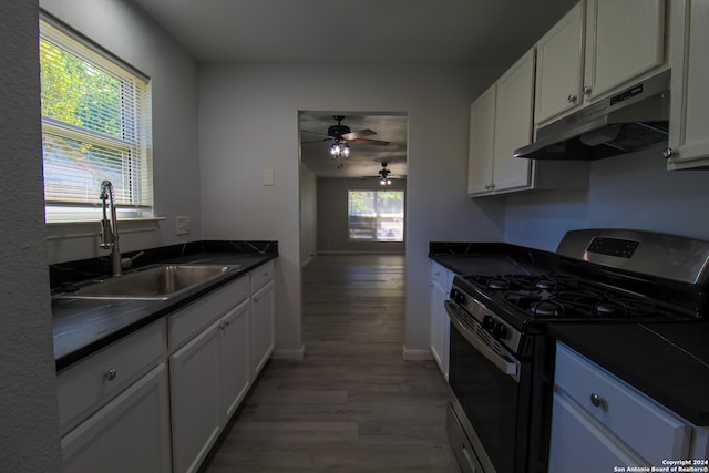 kitchen with white cabinets, hardwood / wood-style flooring, gas range, and sink